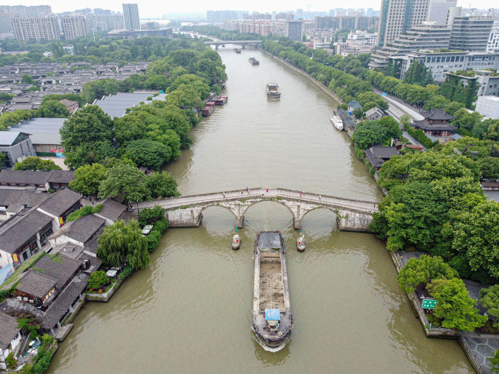5月27日，一艘貨船駛過京杭大運河南端標志建筑杭州拱宸橋。(無人機照片)新華社記者江漢 攝