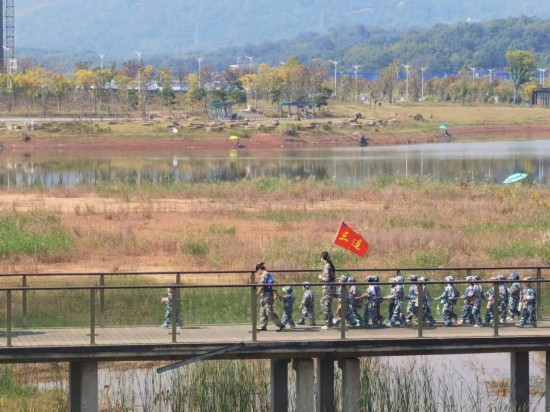 　　10月24日，秋游的幼兒園小朋友在老師帶領(lǐng)下走在清水塘公園里的木橋上。本報記者 常雯宜攝