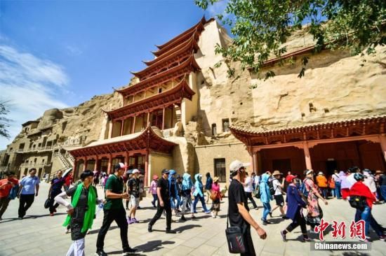 資料圖：莫高窟標(biāo)志性建筑“九層樓”前的游人如織。王斌銀 攝