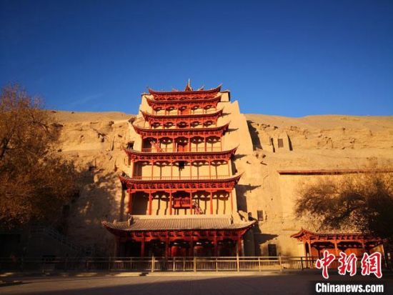 圖為11月7日，沐浴在晨光中的敦煌莫高窟標(biāo)志性建筑“九層樓”?！●T志軍 攝