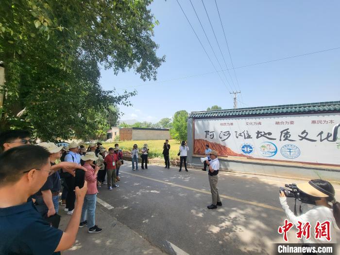 圖為中國地質(zhì)大學(xué)(北京)教授張緒教介紹村落情況。　胡友軍 攝