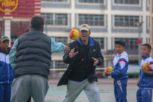 在高原上教孩子們打手球，“慢慢兒來，甭著急！”