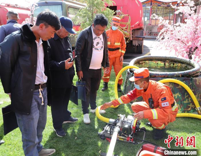 圖為森林消防員為護林員講解滅火裝備的使用方法?！〔际猩窒乐ш?供圖