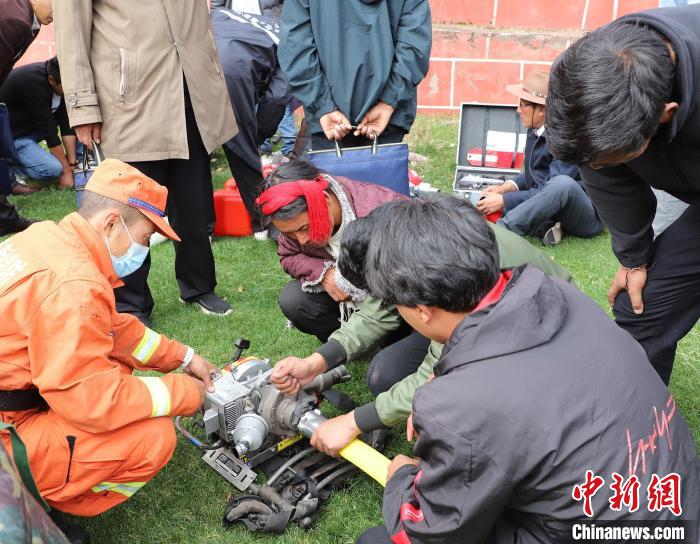 圖為森林消防員為護(hù)林員講解滅火裝備的使用方法。　昌都市森林消防支隊(duì) 供圖