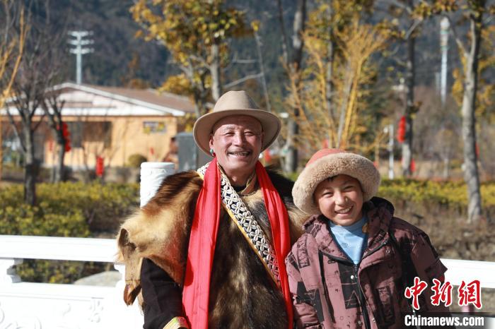 圖為林芝市巴宜區(qū)布久鄉(xiāng)仲果村村民桑杰與孫子一起參加藏歷新年活動(dòng)?！埩?攝