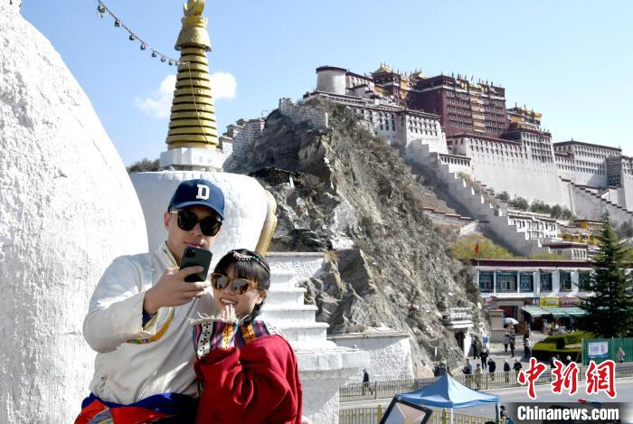 4月17日，游客身著藏式元素服裝在拉薩布達(dá)拉宮觀景臺(tái)拍照留念。　李林 攝